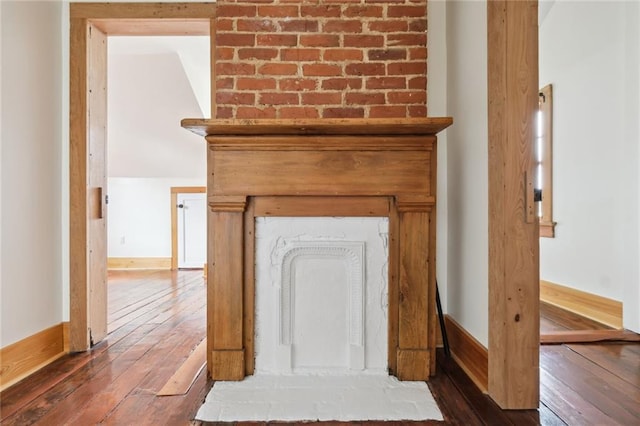 room details featuring a fireplace, wood finished floors, and baseboards