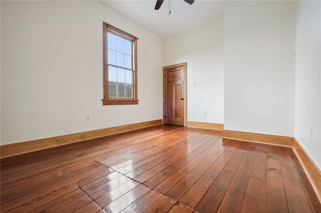 empty room with a ceiling fan, baseboards, and wood finished floors