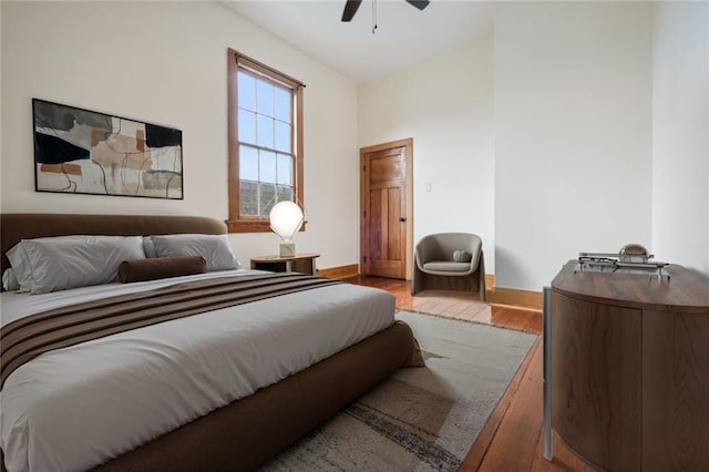 bedroom featuring ceiling fan, light wood-style flooring, and baseboards