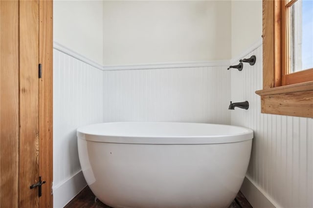 full bath featuring wainscoting and a freestanding tub