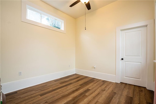 spare room featuring dark wood-style floors, ceiling fan, and baseboards