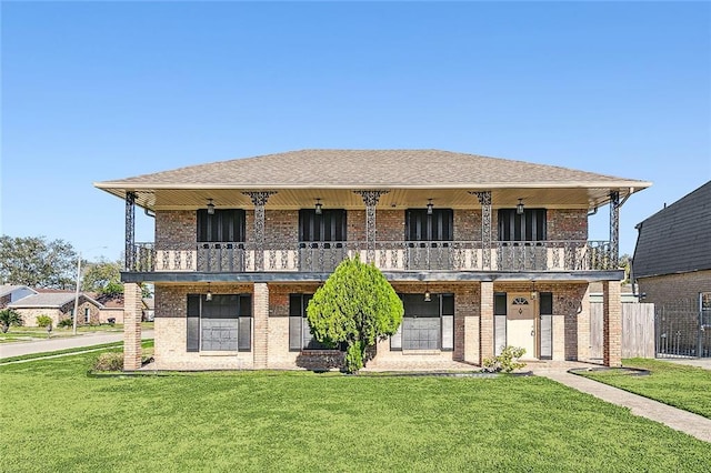 view of front of property featuring a front lawn and a balcony