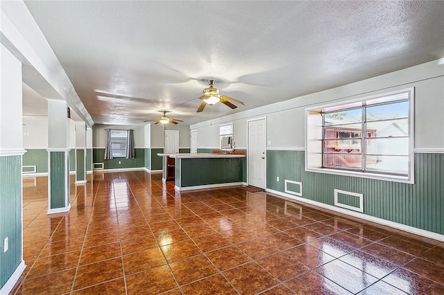 tiled spare room with a textured ceiling and ceiling fan