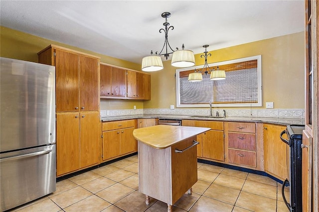 kitchen with light tile patterned flooring, sink, a center island, stainless steel refrigerator, and pendant lighting