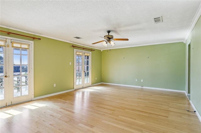 spare room with crown molding, ceiling fan, light hardwood / wood-style floors, a textured ceiling, and french doors