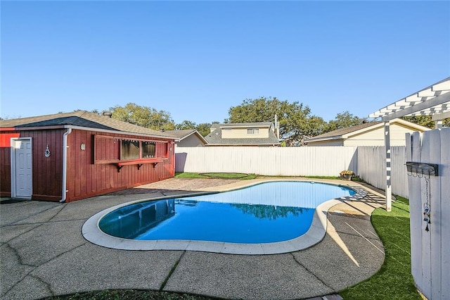 view of swimming pool featuring an outbuilding and a patio