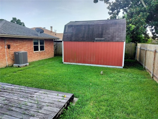 view of yard featuring central AC unit and a storage shed