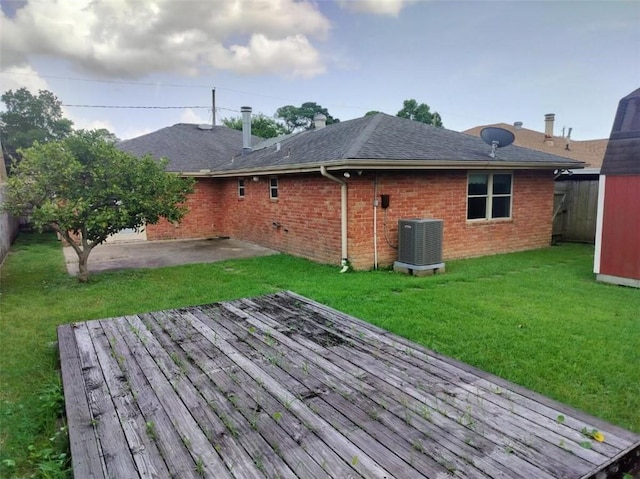 wooden terrace featuring central AC unit, a patio area, and a lawn