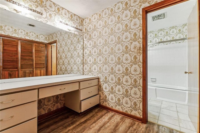 116 Villary St, Belle Chasse, LA 70037 - full bathroom featuring wood finished floors, baseboards, wallpapered walls, vanity, and shower / bath combination