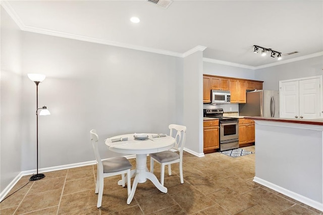 kitchen with crown molding, appliances with stainless steel finishes, pendant lighting, and track lighting