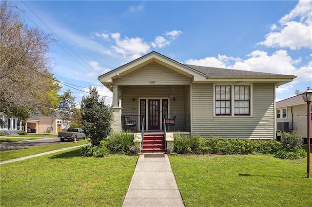 bungalow-style home with a front yard and cooling unit