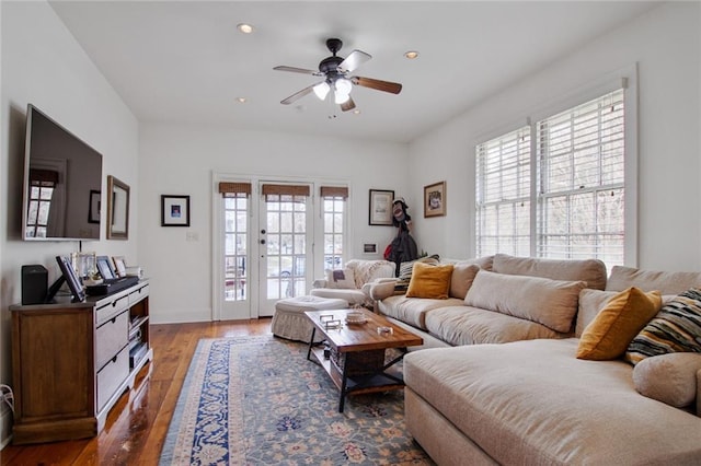 living room with ceiling fan and dark wood-type flooring