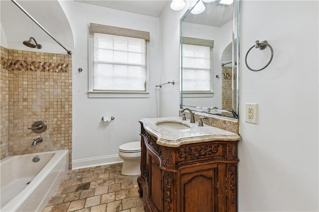 full bathroom with vanity, toilet, and tiled shower / bath