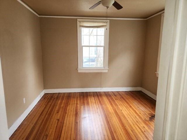 unfurnished room featuring ornamental molding, light wood-type flooring, and baseboards