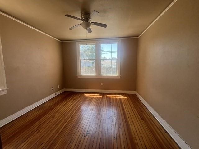 spare room featuring ceiling fan, ornamental molding, dark wood-type flooring, and baseboards