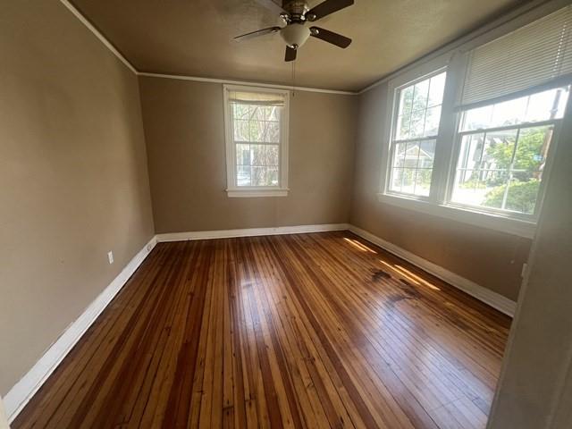 unfurnished room featuring hardwood / wood-style flooring, plenty of natural light, and crown molding