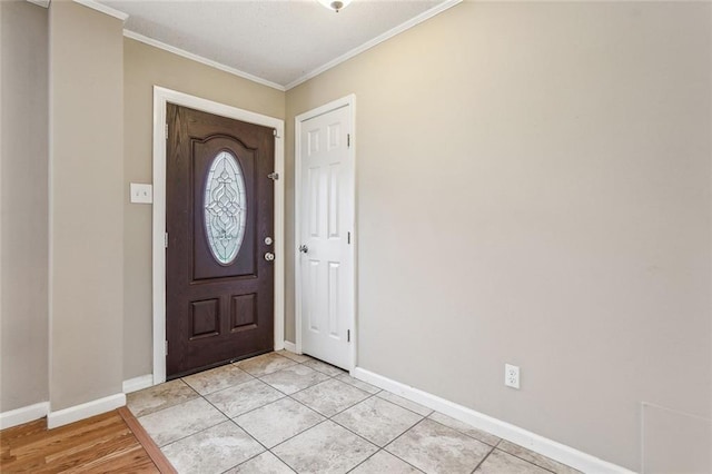 foyer with crown molding and light tile patterned floors