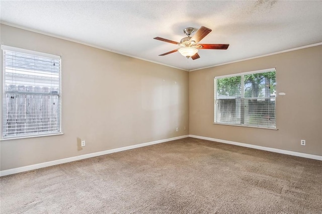 carpeted spare room with crown molding and ceiling fan