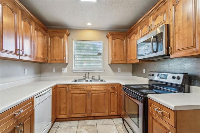 kitchen with stainless steel appliances, sink, a textured ceiling, and light tile patterned floors