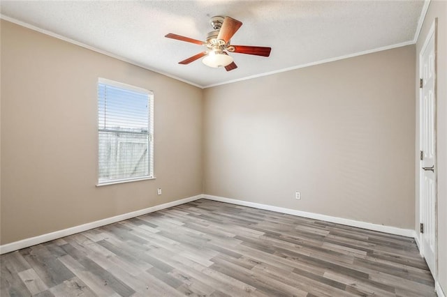 empty room featuring crown molding, ceiling fan, and wood-type flooring