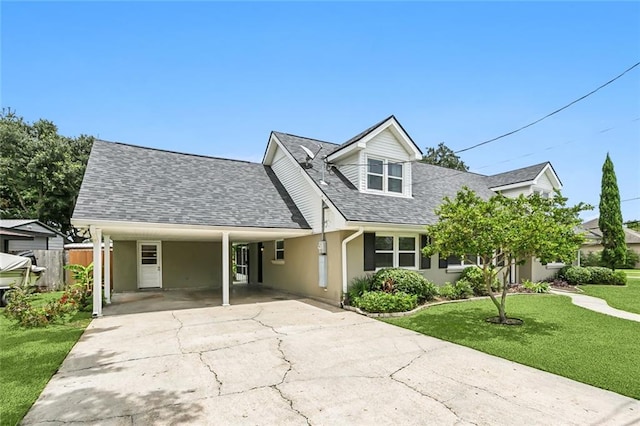 view of front of home with stucco siding, a shingled roof, concrete driveway, a front yard, and an attached carport