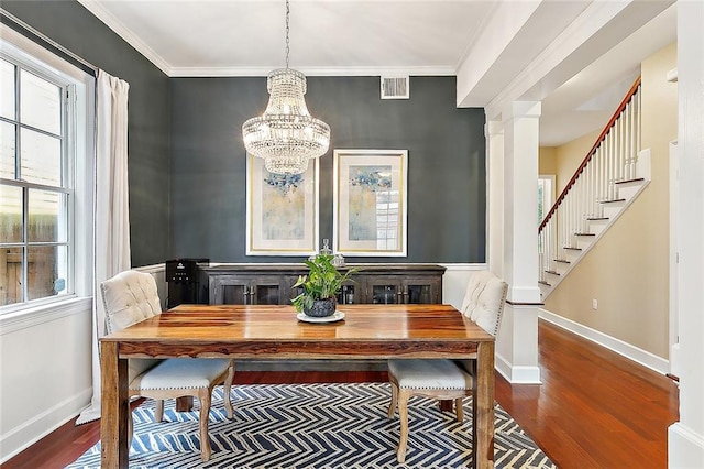 dining area featuring ornamental molding, hardwood / wood-style flooring, a notable chandelier, and a wealth of natural light