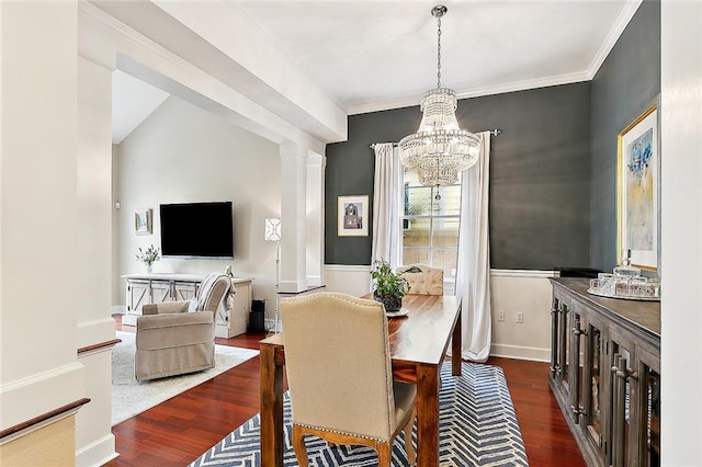 dining area featuring ornamental molding, decorative columns, an inviting chandelier, and wood finished floors