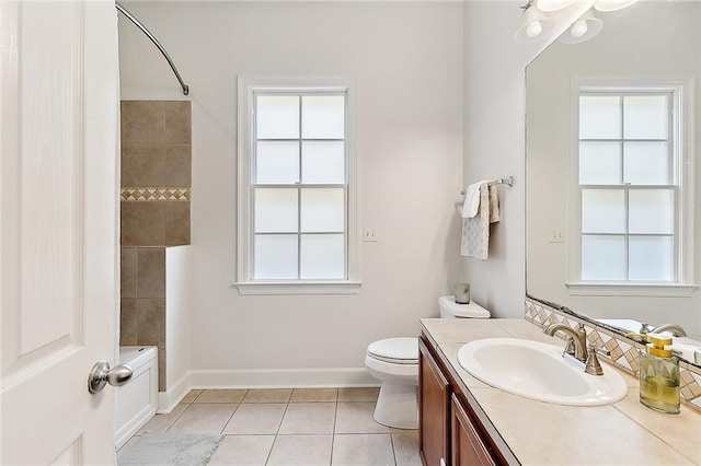 full bath featuring vanity, tile patterned floors, baseboards, and a wealth of natural light