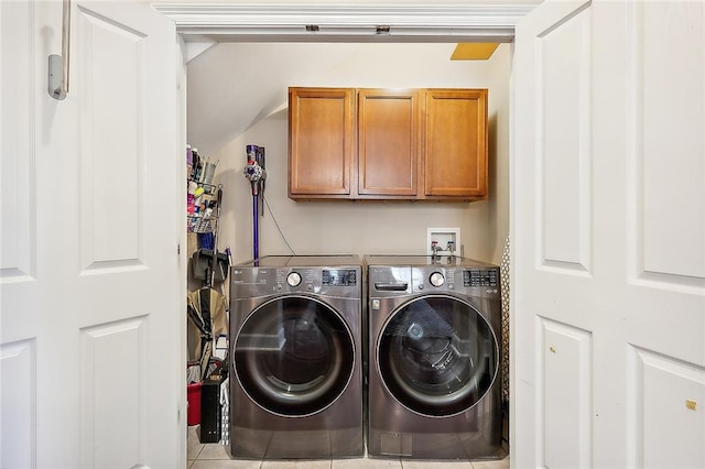 laundry room featuring light tile patterned flooring, separate washer and dryer, and cabinets