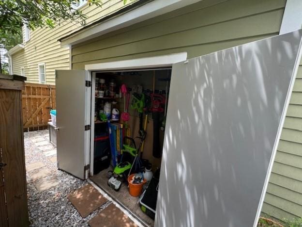 view of outdoor structure featuring a garage and fence