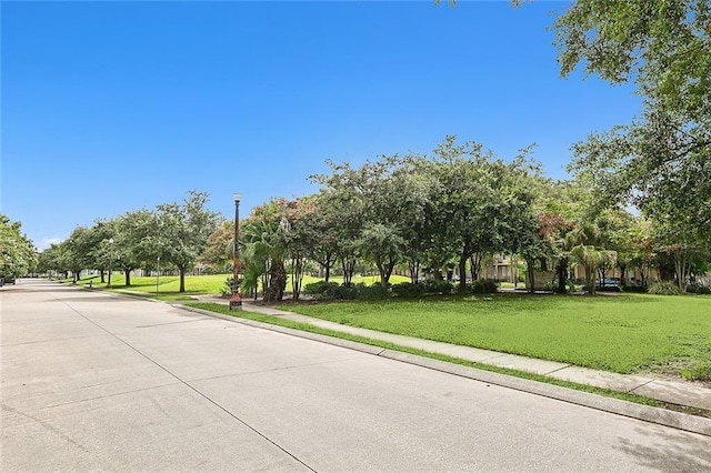 view of road featuring sidewalks, curbs, and street lighting