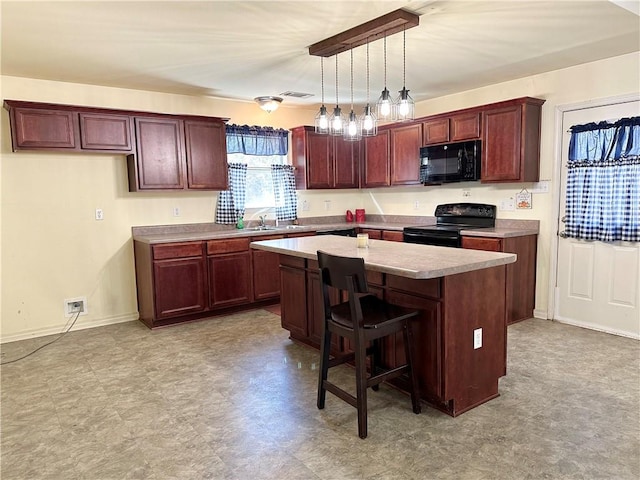 kitchen featuring a breakfast bar, pendant lighting, black appliances, a center island, and sink