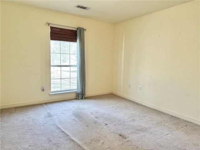 spare room featuring light carpet and a healthy amount of sunlight