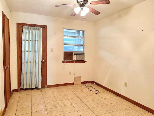 spare room with ceiling fan, cooling unit, a textured ceiling, and light tile patterned flooring