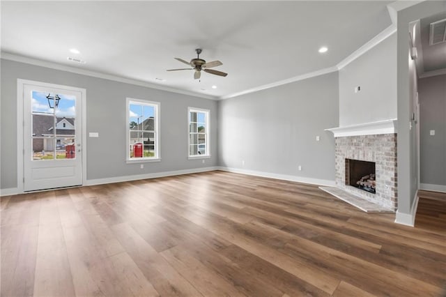 unfurnished living room with a fireplace, crown molding, wood-type flooring, and ceiling fan