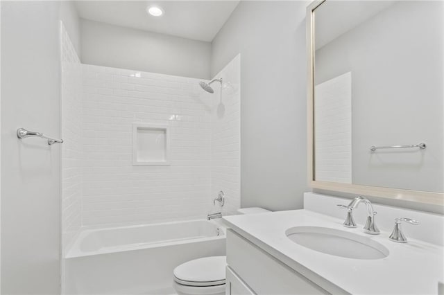 bathroom with washtub / shower combination, vanity, and toilet