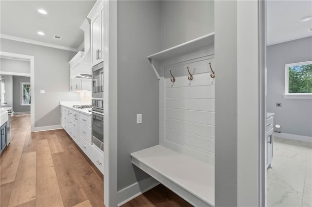 mudroom with crown molding and light hardwood / wood-style floors