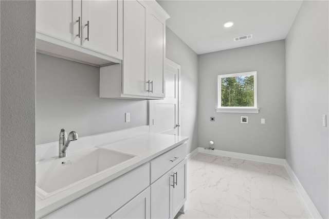 laundry area featuring electric dryer hookup, sink, washer hookup, and cabinets