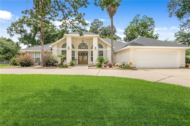 view of front of house with a garage, a front yard, and french doors