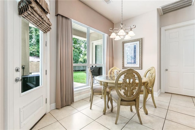 dining space featuring light tile patterned flooring and a notable chandelier