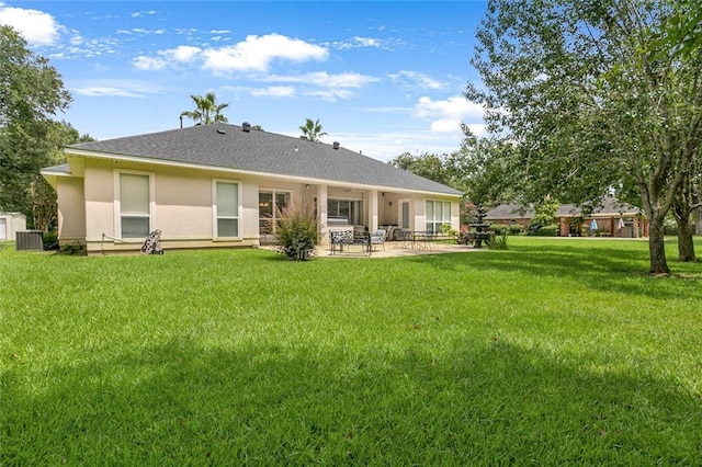 back of property with cooling unit, a patio area, and a lawn