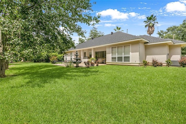 rear view of property featuring a lawn