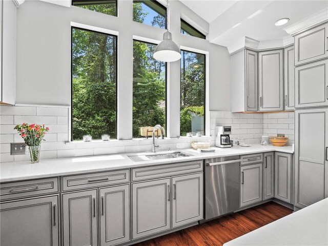 kitchen featuring gray cabinetry, vaulted ceiling, sink, stainless steel dishwasher, and dark hardwood / wood-style flooring