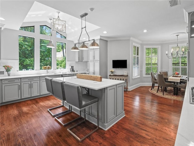 kitchen featuring a notable chandelier, decorative backsplash, dark hardwood / wood-style floors, and gray cabinetry