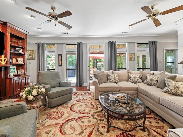 living room featuring a wealth of natural light, ceiling fan, and light wood-type flooring