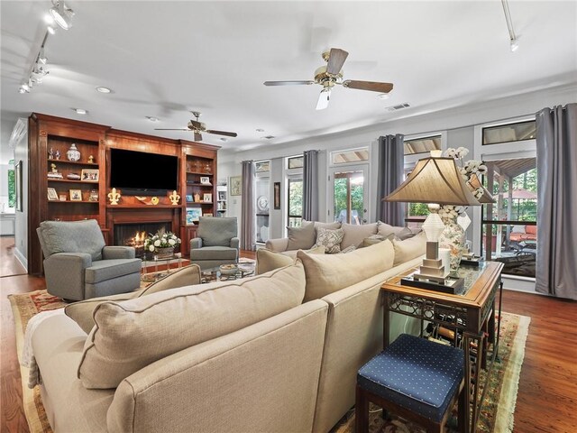 living room featuring ceiling fan, track lighting, hardwood / wood-style floors, and plenty of natural light