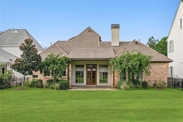 back of property with a patio, a yard, and french doors