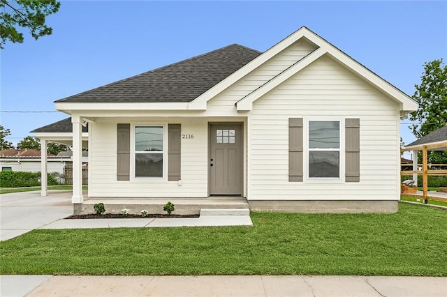 view of front of property with a shingled roof, a porch, and a front lawn