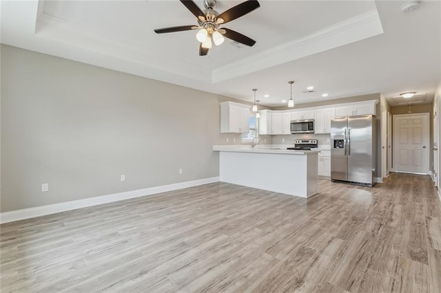 kitchen with stainless steel appliances, a peninsula, white cabinets, light countertops, and pendant lighting