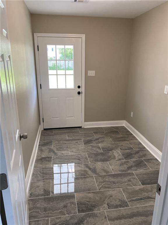 doorway featuring dark tile patterned flooring